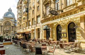 a group of tables and chairs in front of a building at Apartment Faryna in Bucharest