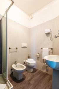 a bathroom with a toilet, sink, and bathtub at Hotel Oleggio Malpensa in Oleggio