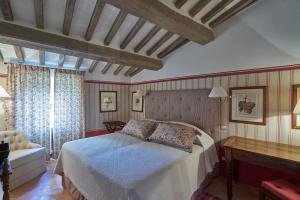 a bedroom with a bed and a desk and a window at Castello di Fighine in San Casciano dei Bagni