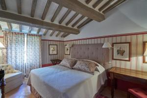 a bedroom with a bed and a desk and a window at Castello di Fighine in San Casciano dei Bagni +48 photos