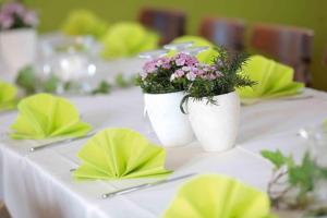 a table with two white vases with flowers on it at Hotel Landgasthof Linde in Nürtingen