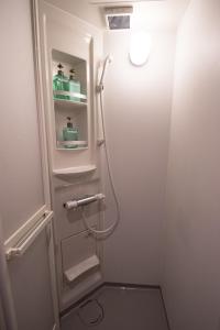 La salle de bains est pourvue d'une douche avec une porte en verre. dans l'établissement ARK NISHIJIN 2 / Vacation STAY 57345, à Fukuoka