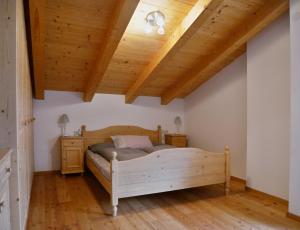 Housetirol في Niederolang: غرفة نوم بسرير وسقف خشبي