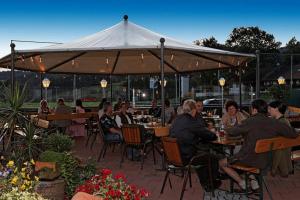 eine Gruppe von Personen, die an Tischen unter einem Zelt sitzen in der Unterkunft Hotel Winterl in Bernried