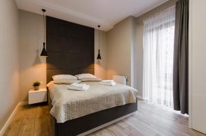 Posteľ alebo postele v izbe v ubytovaní Krakowiak Apartments
