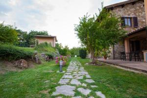 a garden with a stone path in front of a house at Relais Parco Del Subasio in Piano Delle Pieve