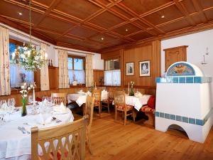 un comedor con mesas y sillas blancas en Natur-&Alpinhotel Post en Vent