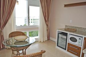 a kitchen with a glass table and a window at Hotel Atlantico Rio Grande in Rio Grande +30 photos