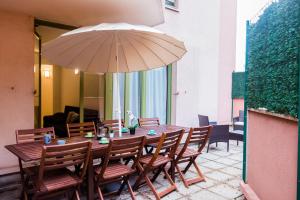 a wooden table with chairs and a large umbrella at D&E - PARIS-DISNEY - HOLIDAYS APARTMENT - APPARTEMENT DE VACANCES - 5 CHAMBRES- 5 SDB - 5 BEDROOMS - 5 BATHROOMS - Netflix in Champs-sur-Marne