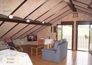 salon z kanapą i stołem w obiekcie Apartamentos Rurales Monfragüe w mieście Torrejón el Rubio
