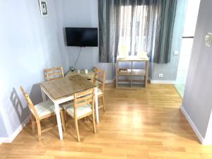 a dining room with a table and chairs and a television at Resitur Luxury Apartment 113 in Seville