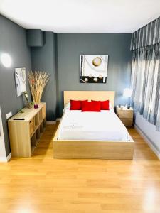 Un dormitorio con una cama con almohadas rojas. en Resitur Luxury Apartment 113, en Sevilla