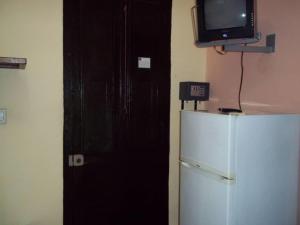 a black door with a tv on top of a refrigerator at Casa Colonial La Terraza in Havana