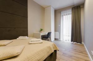 - une chambre avec 2 lits, un bureau et une fenêtre dans l'établissement Krakowiak Apartments, à Cracovie