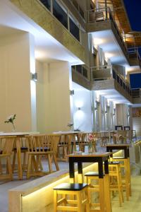 a restaurant with wooden tables and chairs and lights at Grand TheoNi Boutique Hotel & Spa in Vasiliki