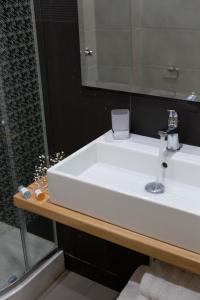 a bathroom with a white sink and a mirror at Grand TheoNi Boutique Hotel & Spa in Vasiliki