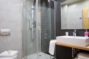 a bathroom with a shower and a sink at Grand TheoNi Boutique Hotel & Spa in Vasiliki