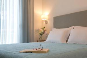 a bed with a tray with a pair of glasses on it at Grand TheoNi Boutique Hotel & Spa in Vasiliki