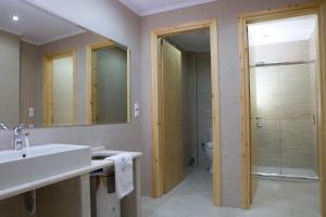a bathroom with a sink and a toilet and a mirror at Grand TheoNi Boutique Hotel & Spa in Vasiliki