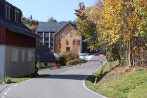 a winding road in a village with buildings at Apartman Milíř - ADULTS ONLY in Bedřichov