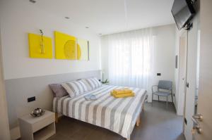 VARESE COMFORT ROOM في فاريزي: غرفة نوم صغيرة بها سرير وكرسي