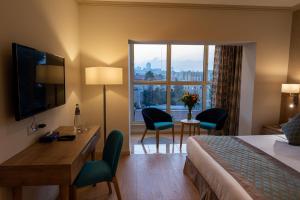 a hotel room with a bed and a desk and chairs at Ambassador Boutique Hotel in Jerusalem