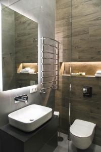 uma casa de banho com um lavatório, um WC e um espelho. em Apart Hotel на Трояндовой em Chernivtsi