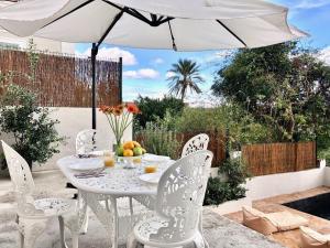 a white table and chairs under an umbrella at VILLA CAMPANA - Bastia centre in Bastia