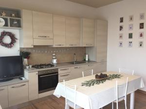 cocina con mesa de comedor y TV en Igea Mare, en Bellaria-Igea Marina