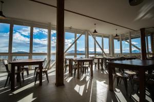 un restaurante con mesas, sillas y ventanas grandes en Best Western Patagonia, en Puerto Natales