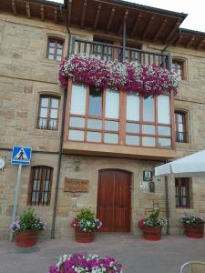 a building with a balcony with flowers on it at El Cuartelillo Viejo in Polientes
