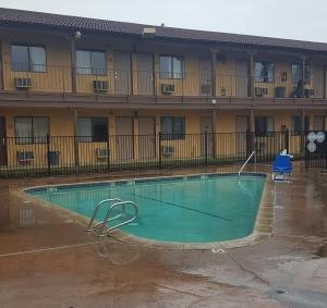 a swimming pool in front of a building at Best Economy Inn & Suites in Bakersfield