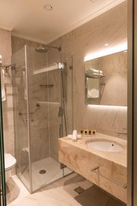 a bathroom with a glass shower and a sink at Ambassador Boutique Hotel in Jerusalem