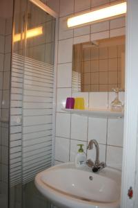W łazience znajduje się umywalka i lustro. w obiekcie Partvilla Balatonboglar w mieście Balatonboglár