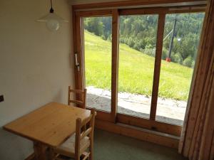 a dining room with a table and a large window at Valmorel Studio Skis aux pieds in Valmorel