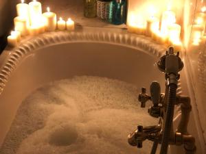 a bath tub with candles and snow in it at Old Barn, Beach Farm Hunstanton - Dog Friendly in Heacham +79 photos