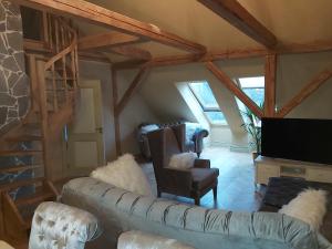 a living room with a couch and a tv at Vanalinna apartement in Viljandi