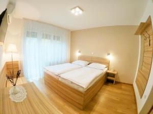 a bedroom with a large bed and a window at Stara lipa Tašner kitchen & P & garage in Maribor