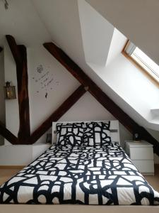 a bedroom with a black and white bed in a attic at Atelier des Poèmes. in Montbéliard