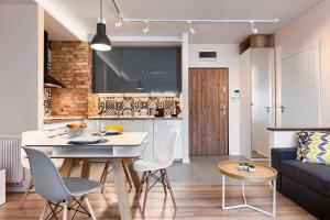 kuchnia i salon ze stołem i krzesłami w obiekcie City Centre Modern Apartment Poznań Free Parking w Poznaniu