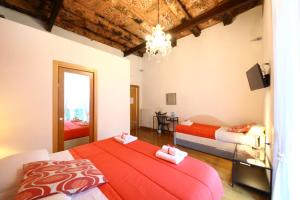 1 dormitorio con 2 camas y lámpara de araña en Talismano Luxury Rooms & Apartments, en Nápoles