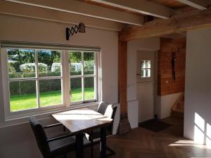 a dining room with a table and a window at De Cromvoirtse Bed and Breakfast in Cromvoirt