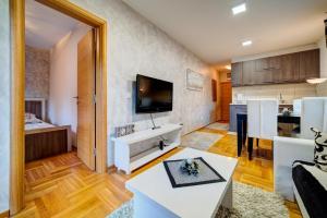 una sala de estar con cocina y una habitación con mesa en Apartment Dara, en Zlatibor