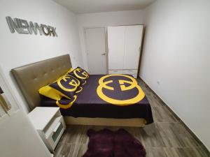 Un dormitorio con una cama con signo de acedes. en Apartamentos New York, en Vecindario