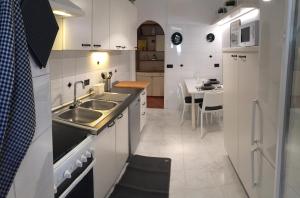 a white kitchen with a sink and a table at Il giardino nascosto in Rome