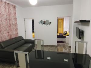 een woonkamer met een bank en een glazen tafel bij Apartamentos New York in Vecindario