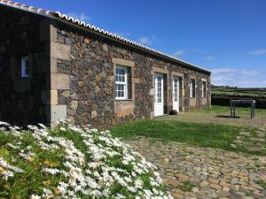 a stone building with flowers in front of it at Pico da Vigia in Santa Bárbara