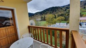 a balcony with a table and a view of a mountain at Appart La Bresse - Idéal Famille - Entre Village et Station in La Bresse