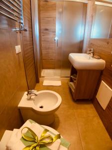 uma casa de banho com um WC, um lavatório e um chuveiro em Hotel Smeraldo em Qualiano