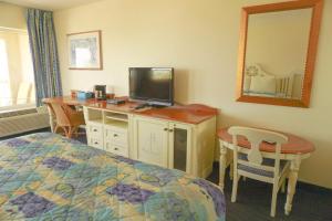 1 dormitorio con 1 cama y escritorio con TV en Oceanview Lodge - Saint Augustine en Saint Augustine